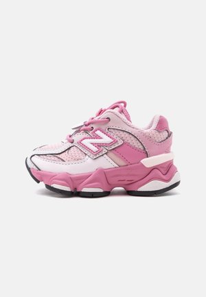 Baskets enfant rose et blanc en tissu mesh, fermeture à lacets et semelle épaisse texturée, vues de côté sur fond blanc.