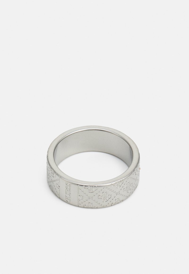 Anneau en métal ton argent gravé d'un motif de logo répétitif et du mot "GUESS" sur un fond blanc uni.