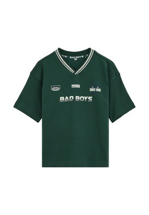 Tricou verde închis cu mâneci scurte și decolteu în V, cu guler cu dungi albe și text imprimat pe față "BAD BOYS," "SOCCER LEAGUE" și "SINCE 1988".