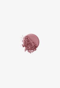 Fard à joues rond et compact dans un rose pâle atténué, avec une texture en poudre broyée, présentant une surface lisse et des fragments dispersés.