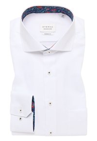 Camicia bianca a maniche lunghe con taglio moderno. Presenta un colletto interno e dei polsini a fantasia floreale blu, cinque bottoni e una texture in cotone morbido.
