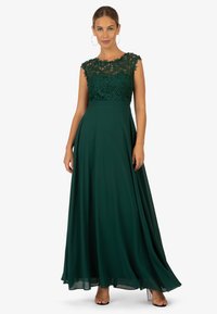 Bodenlanges Kleid in tiefem Grün mit einem Spitzenoberteil und kurzen Ärmeln, abgerundet durch einen fließenden Rock und eine taillierte Taille. Glatte Stoffstruktur.