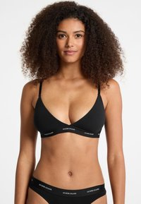 Black triangular bralette and matching brief with logo waistband. Soft, stretchy fabric, featuring adjustable straps and minimalistic design.