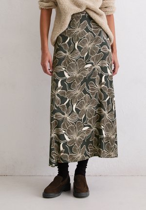 Maxi rok in donkergroen met een beige bloemenpatroon. De stof is zacht en vloeiend, met een gladde textuur en een ontspannen pasvorm.