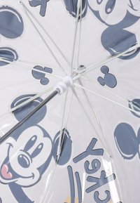 Parapluie transparent avec un canopy blanc orné de visages de Mickey Mouse dans un style cartoon et des accents bleus, soutenu par une quincaillerie blanche et argentée.