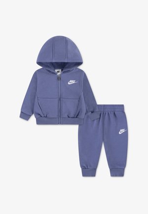 Set de trening violet din material moale, compus dintr-o jachetă cu fermoar și glugă și pantaloni elastici asortați. Accente cu logo alb.