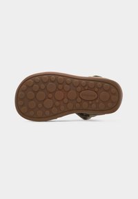 Καφέ λαστιχένια σόλα παιδικού σανδάλιου με διάφορα μεγέθη κυκλικών ανωμαλιών και το λογότυπο "bisgaard" στο κέντρο.