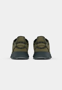 Green athletic shoes with a textured upper, rounded toe, and black rubber sole. Features loop eyelets and padded collar.