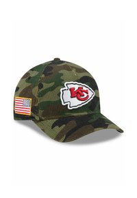 Grüne Camouflage-Basecap mit einem gebogenen Schild, das ein gesticktes rotes "KC"-Logo und ein USA-Flaggen-Patch an der Seite aufweist. Texturiertes Material.