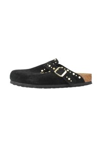 Sabot en nubuck noir avec semelle en liège, doté d'une sangle réglable avec boucle en or et de clous dorés le long de la sangle et du bord supérieur.