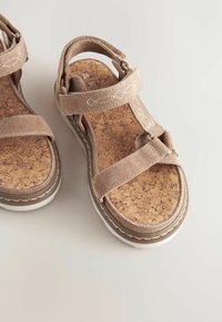 Beige parafa szandálok két textilpánttal, állítható záródással, texturált talppal és fehér kontrasztos díszítéssel. Simaságú, bőrszerű felső felület.