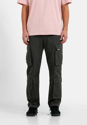 Cargobroek in donkergrijze stof met meerdere zijzakken en een rechte pijpdesign, gecombineerd met een lichtroze t-shirt.