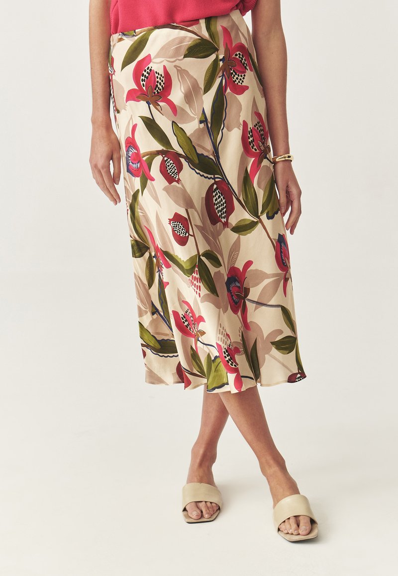 Jupe midi florale en beige avec des motifs roses et verts ; fabriquée en tissu lisse, avec un design fluide et des accents superposés.