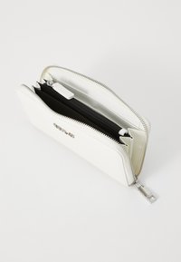 White wallet made of smooth material featuring a silver zipper. Interior includes black compartments for organization.