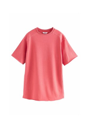 Coral pink oversized short-sleeve crew neck sweatshirt with visible seam details and soft fabric texture on white background.