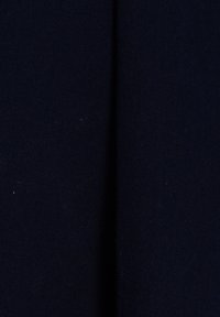 Vue rapprochée d'un tissu bleu marine foncé avec une fine texture côtelée verticale et un pli ombré au centre.