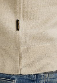 Bežani pleteni džemper s rebrastim rubom i bočnim šavom, s black and yellow "PME Legend" oznakom na lijevoj strani.