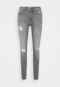 Grå slim jeans i denim med slitna detaljer. Har en medelhög midja, femficksdesign och fransad fåll vid ankeln.