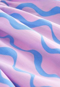 Stof met golvende patronen in blauw op een roze achtergrond, met een zachte textuur en een soepele val, die een levendig contrast in kleuren toont.