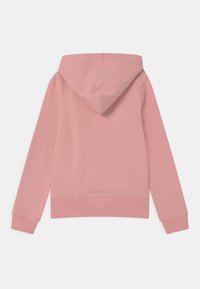 Vaativa vaaleanpunainen huppari pitkät hihat, valmistettu pehmeästä kankaasta. Ominaisuuksiin kuuluu rento istuvuus, ribattuja hihansuita ja helma. Yksinkertainen design ilman lisäkoristeita.