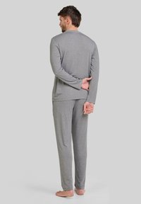 Top de manga larga gris y pantalones a juego, hechos de una tela suave. El diseño de corte relajado presenta un escote redondo y una cintura elástica.