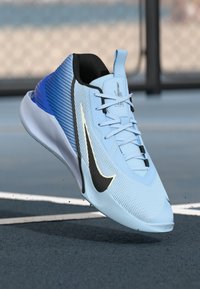 Light blue athletic shoe with a textured upper, black and silver accents, and a bold blue heel. Features laces and a sleek design.