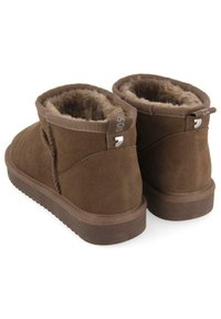 Botas de tobillo de ante marrón con forro de pelo sintético, suela de goma plana, talón reforzado y detalle de logo en la parte trasera para un fácil uso.