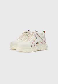 Baskets blanches avec une semelle épaisse, offrant des accents arc-en-ciel, des lacets texturés et un onglet coloré à l'arrière. Matière synthétique lisse.