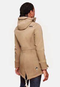 Beige waterproof jacket with a hood, drawstring waist, and decorative side vent. Features a logo on the upper back and pocket tag.