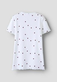 Camiseta blanca de manga corta con textura acanalada, que presenta un patrón de corazones color burdeos dispersos y un dobladillo festoneado.