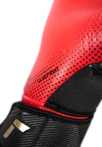 Rote und schwarze Sporthandschuhe mit einer strukturierten Oberfläche, gepunktetem Muster im roten Bereich und einem sichtbaren Logo mit der Aufschrift "BLUEPRINT".