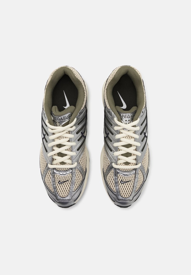 Nike Pegasus Sneaker in Beige und Grau mit Mesh-Obermaterial, silbernen Akzenten, schwarzem Logo und weißen Schnürsenkeln. Gepolstertes Innenfutter.