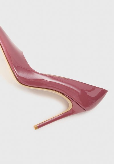 Patented high-heeled shoe with a pointed toe, burgundy color, glossy finish, and a slim gold-accented heel. Smooth texture and sleek design.