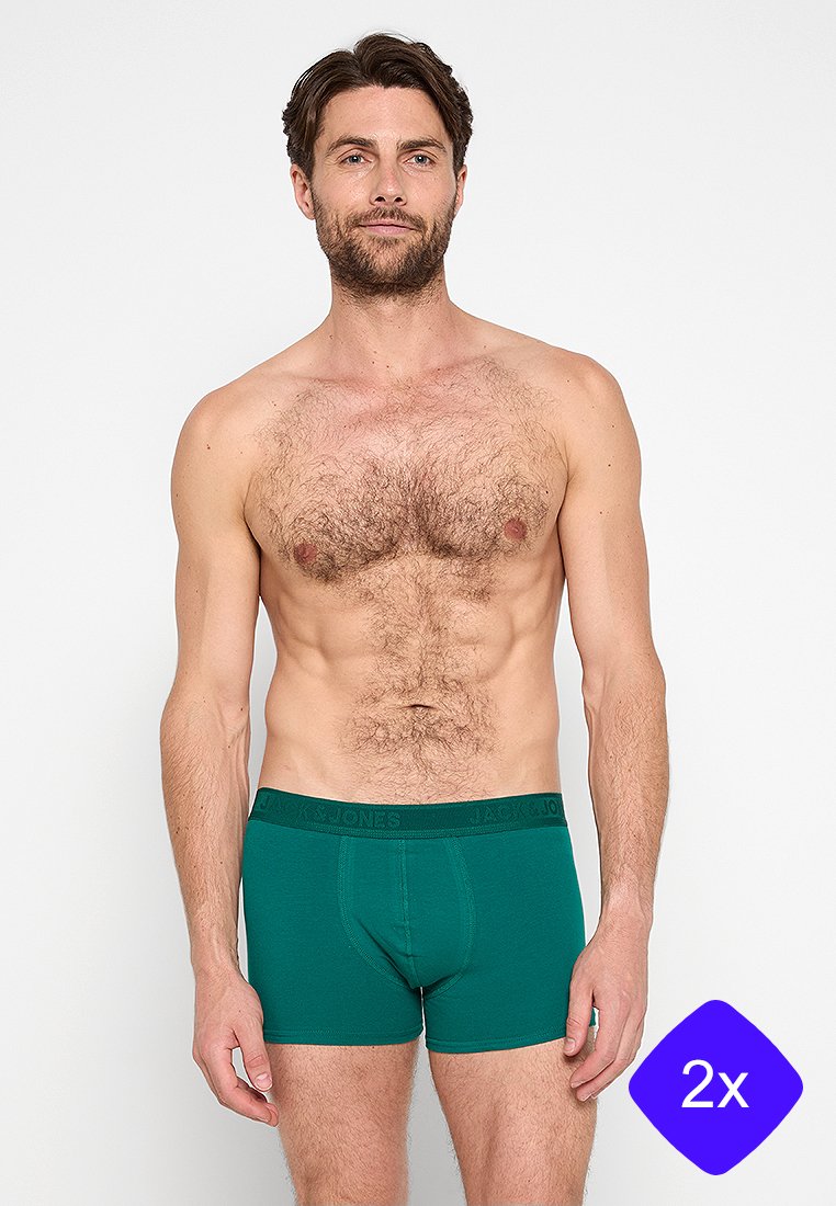 Boxers de algodón verdes con una cinturilla negra, que cuentan con un ajuste ceñido y material elástico, mostrados en un modelo masculino sobre un fondo liso.