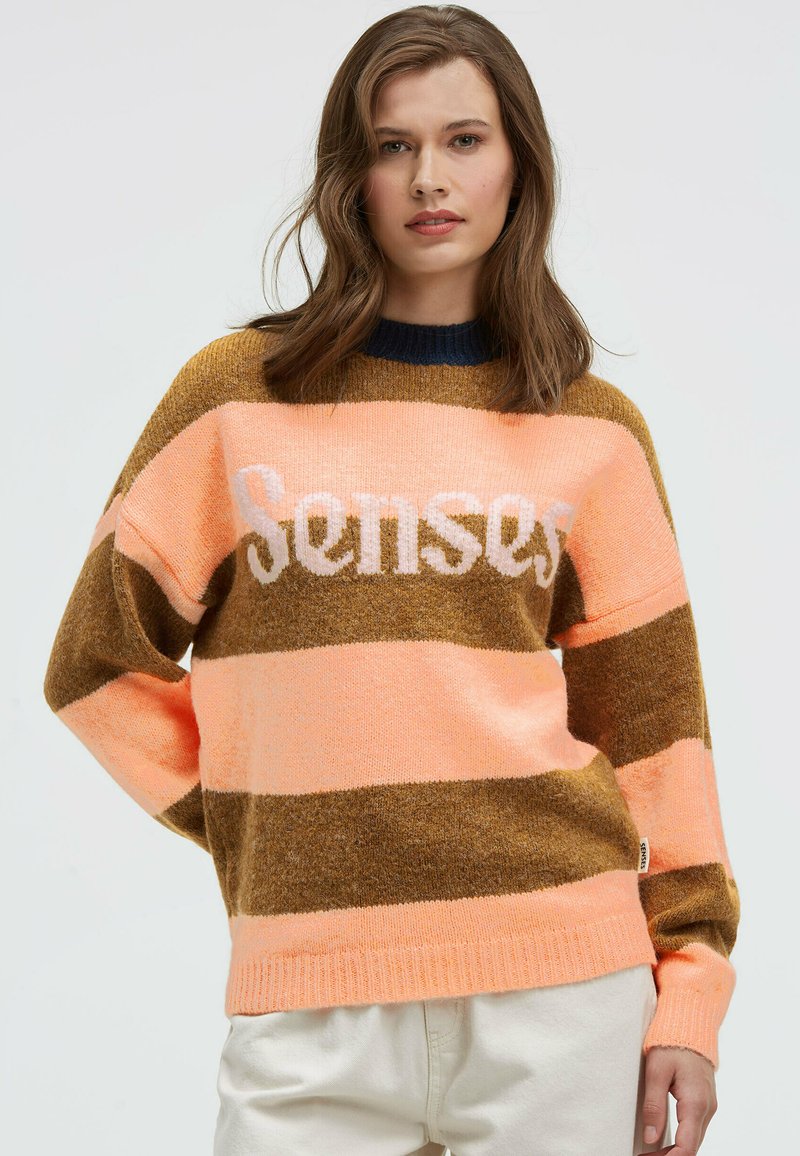 Knitted sweater with horizontal stripes in pink, brown, and beige. Features a crew neckline and the word "Senses" in white across the chest.