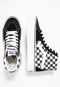 Schwarz-weiße High-Top-Sneaker aus Wildleder mit kariertem Muster, weißen Schnürsenkeln, gepolstertem Kragen und Signature-Logo auf der Zunge.