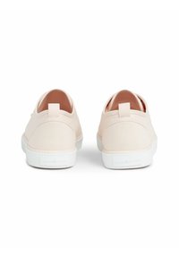 Jasnoróżowe płócienne buty typu slip-on z fakturowanym wykończeniem, białą gumową podeszwą i małą pętlą z tyłu dla ułatwienia zakładania. Logo marki na pięcie.