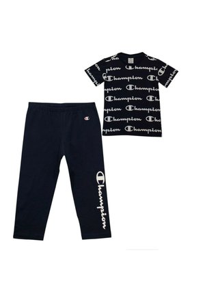 Completo a due pezzi blu navy composto da una t-shirt a maniche corte con logo "Champion" ripetuto e pantaloni abbinati con logo sulla gamba sinistra.