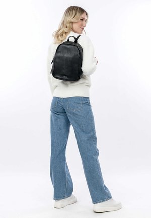 Zaino in pelle nera con una texture liscia, forma rettangolare e manico superiore. Presenta due scomparti con zip e hardware minimale.