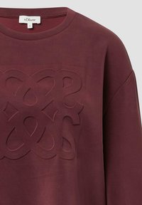 Bordeaux sweatshirt met een gestructureerd, verhoogd patroon in het midden. Heeft een ronde halslijn en lange mouwen, gemaakt van zacht materiaal.