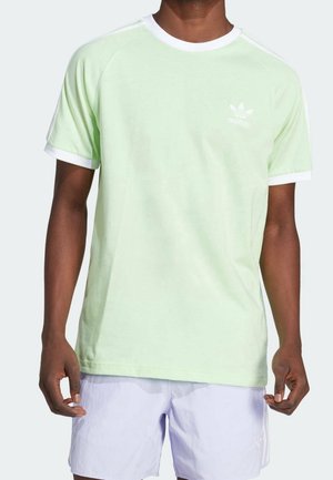 Lichtgroene katoenen t-shirt met witte kraag en mouwboorden, voorzien van een klein wit Adidas-logo op de linkerborst. Casual fit met korte mouwen.