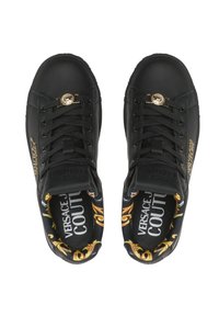 Baskets en cuir noir avec quincaillerie dorée, impression intérieure complexe, système de laçage et marquage sur les côtés et la semelle intérieure.