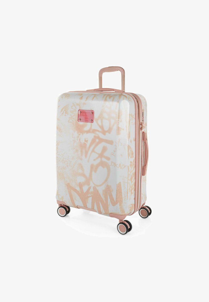 Maleta rígida con una base blanca y diseños estilo graffiti en rosa claro. Cuenta con un asa retráctil y cuatro ruedas negras.