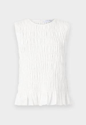 Hvit ermeløs topp med rynket tekstur, med rund hals og volangkant. Laget av myk, lett stoff.