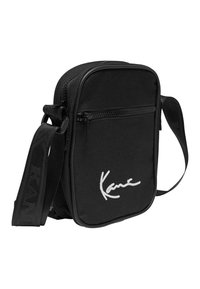 Borsa a tracolla nera con un tessuto texturizzato, tasca anteriore con zip e logo bianco. Presenta una tracolla regolabile per una maggiore comodità.