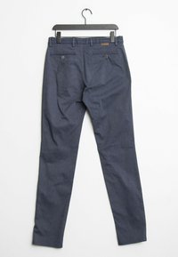 Pantalons bleu marine en tissu texturé, avec une coupe slim, deux poches arrière avec des boutons et une taille avec des passants de ceinture.