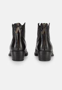 Botas de tobillo de cuero negro con un acabado texturizado, que cuentan con una cremallera en la parte posterior, punta redondeada y un tacón bajo tipo bloque.