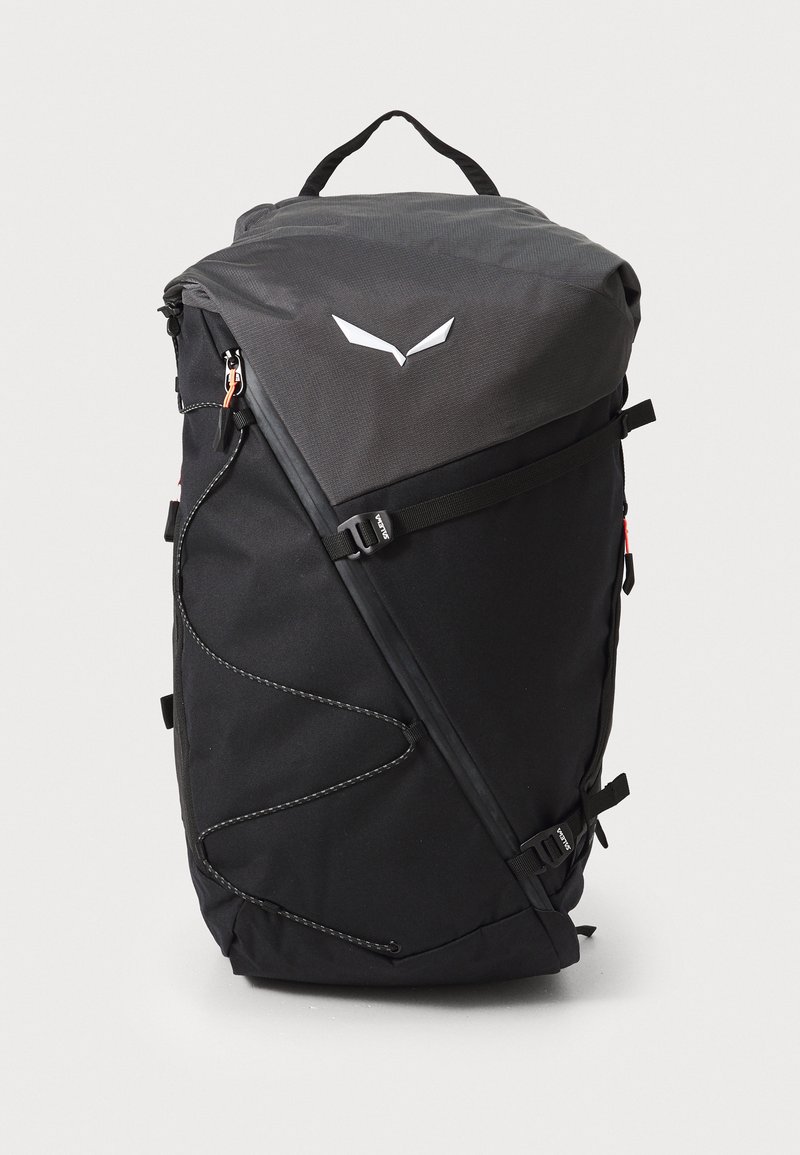Zaino nero con un design geometrico, realizzato in tessuto resistente, presenta una cerniera curva, spallacci regolabili e una maniglia superiore per un trasporto facile.