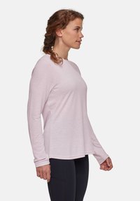 Lichtroze langwerpig shirt met een ronde halslijn, gemaakt van zachte stof, met subtiele logodetails op de borst en een relaxte pasvorm.