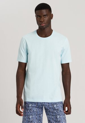 Light blue short-sleeve t-shirt in soft cotton, featuring a crew neck and a relaxed fit. Worn with patterned blue shorts.